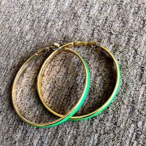 Green and gold colored hoop earrings.